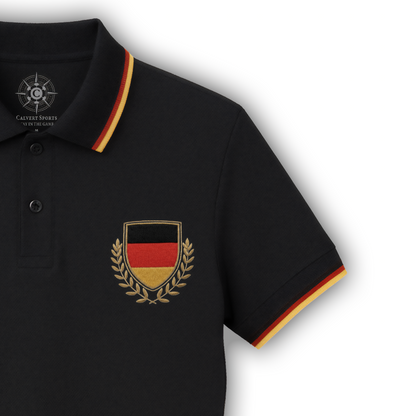 Rechte Vorderseite des schwarzen Fan-Polo Deutschland 2026 mit schwarz-rot-goldenen Streifen an Kragen und Bündchen sowie Deutschland-Wappen