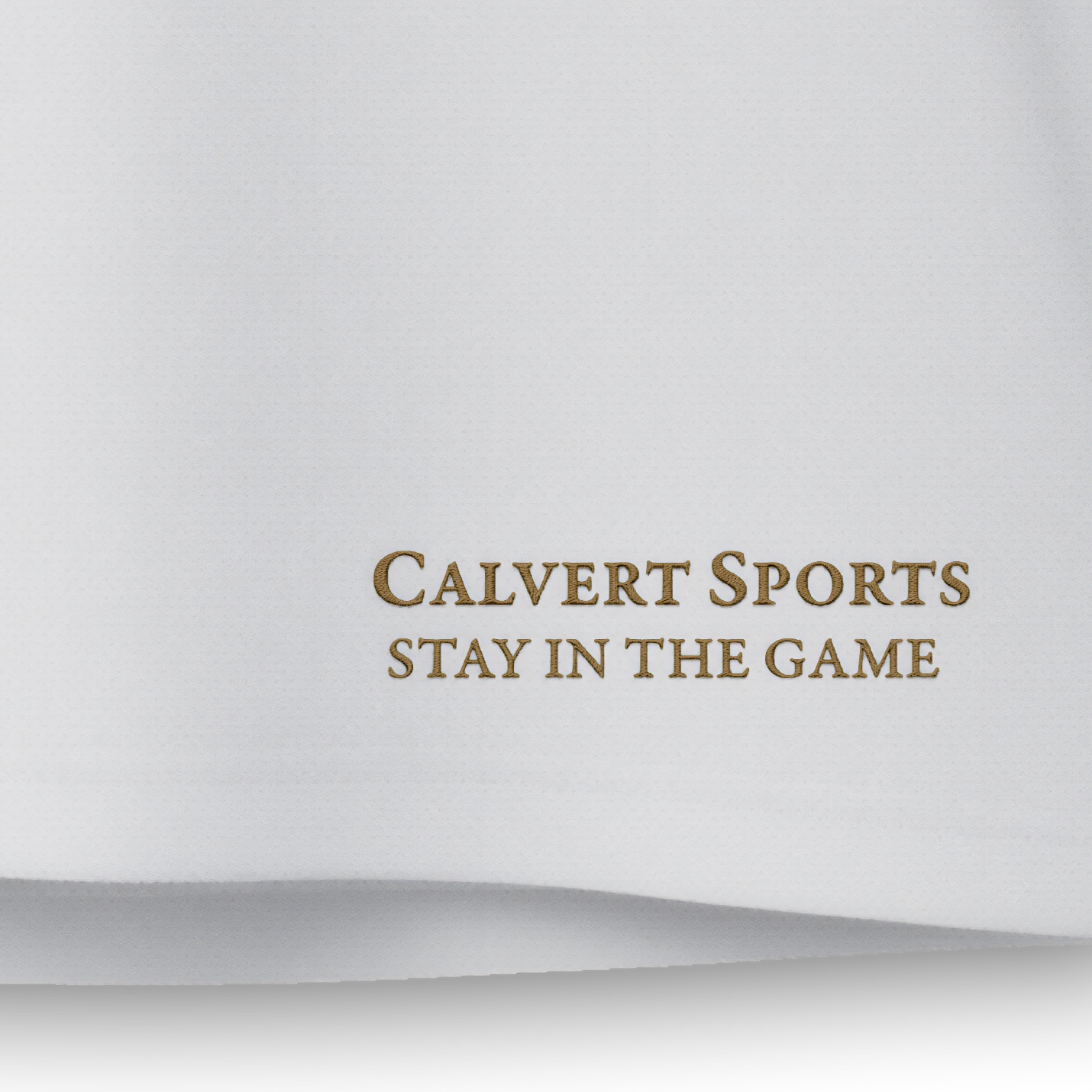 Gesticktes CALVERT SPORTS Schriftlogo mit Claim ‚Stay in the Game‘ in Gold auf dem weißen Fan-Polo Deutschland 2026