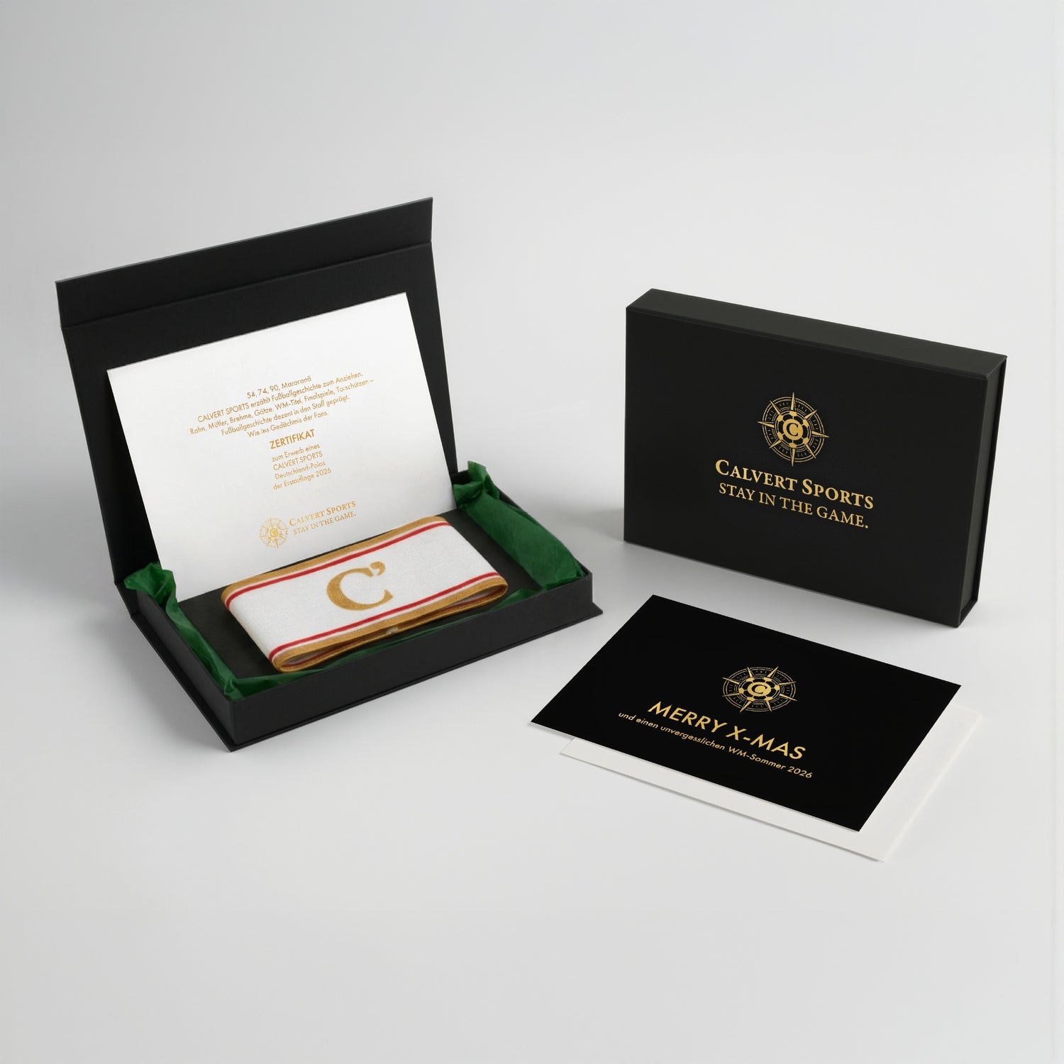 Geschenkbox des Fan-Polo Deutschland 2026 mit Kapitänsbinde in Grün, Erstauflagenzertifikat und Weihnachtskarte