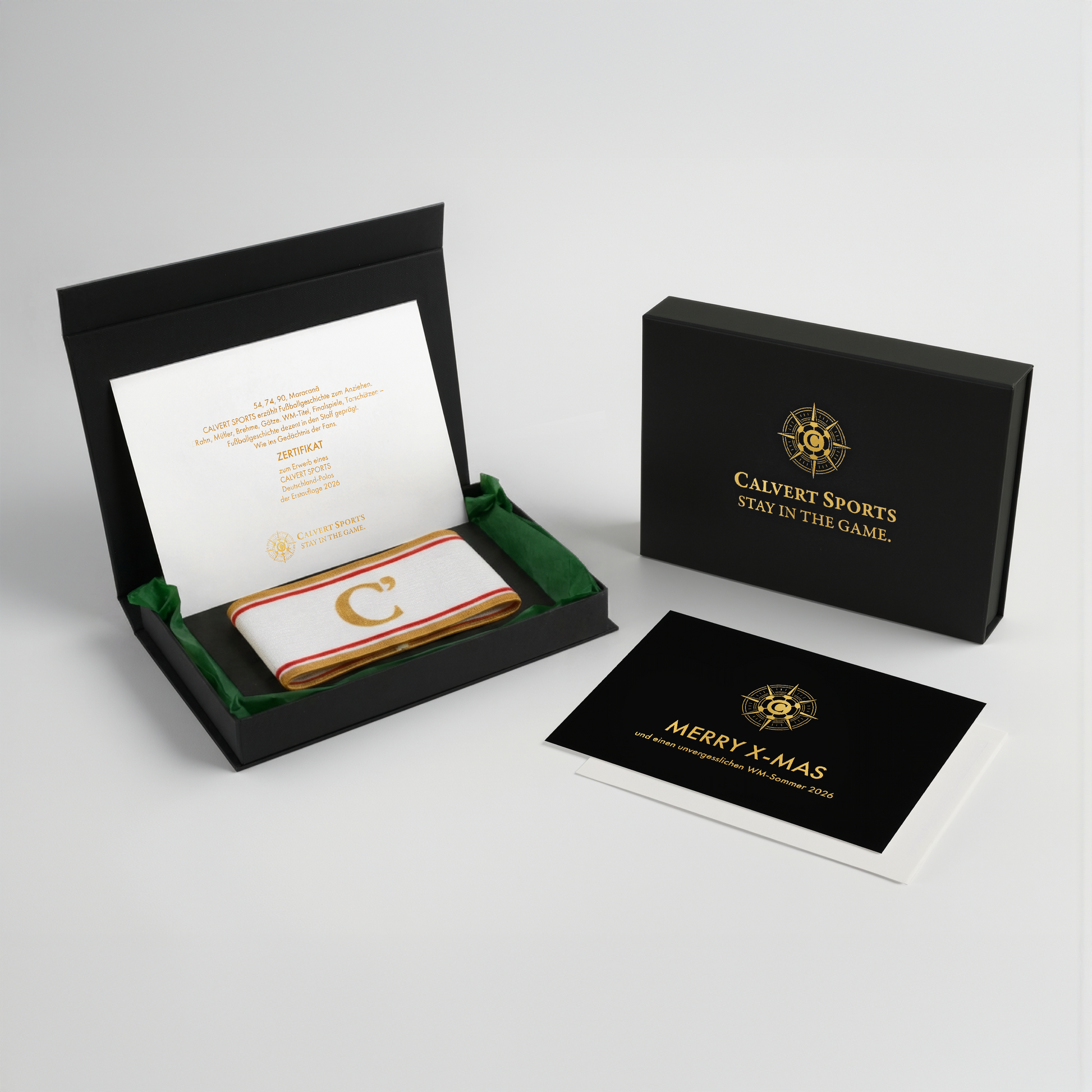 Geschenkbox des Fan-Polo Deutschland 2026 mit Kapitänsbinde in Grün, Erstauflagenzertifikat und Weihnachtskarte