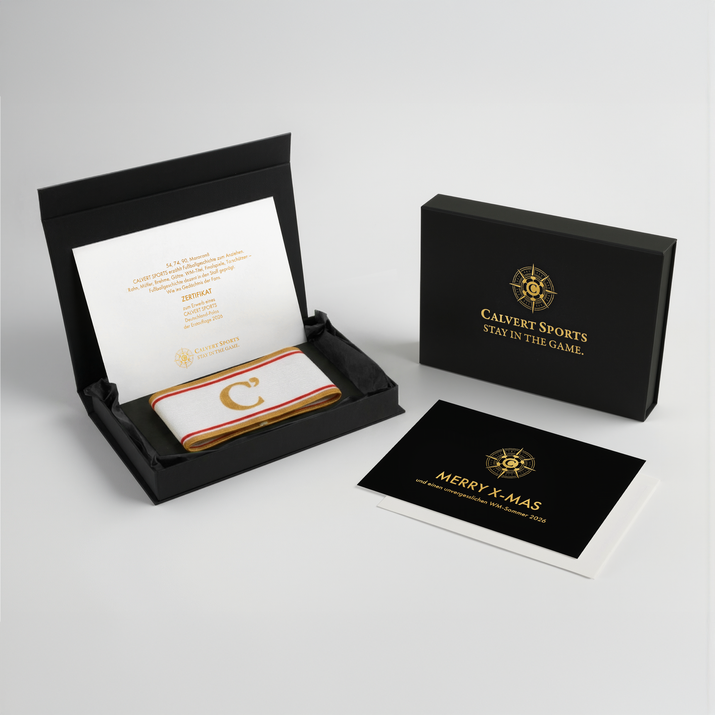 Geschenkbox des Fan-Polo Deutschland 2026 mit Kapitänsbinde in Schwarz, Erstauflagenzertifikat und Weihnachtskarte